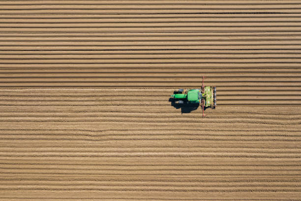 vista aérea del arado y pulverización de tractores agrícolas en el campo.  agricultura. vista desde arriba. foto capturada con drone. - tractor green farm corn fotografías e imágenes de stock