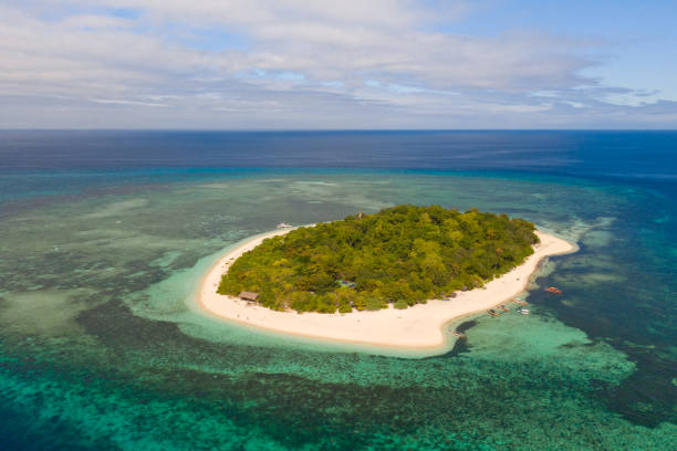 istock A small island surrounded by azure water and coral reefs, a top view 1159046459