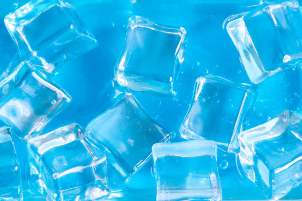 Close up of ice cubes against blue background minimal creative concept.
