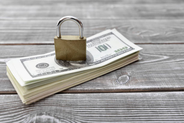 istock money dollars, closed lock on a wooden background. 1159049772