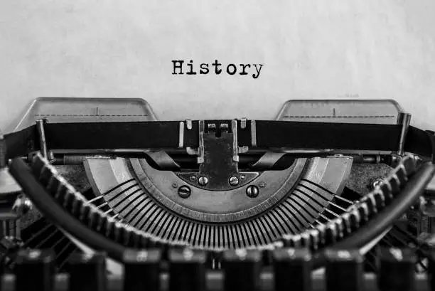 Photo of History typed on an vintage typewriter, old paper.