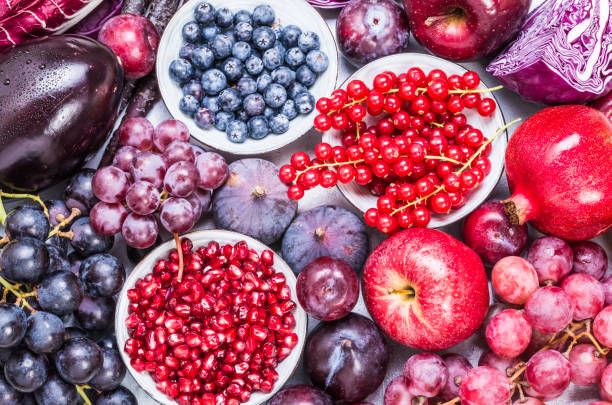 Purple and red color fruits and vegetables top view. Purple and red color fruits and vegetables ingredients top view on rustic white background. plum red white purple stock pictures, royalty-free photos & images