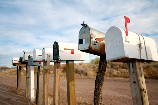 weathered American mailbox against blue sky