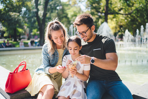 Young family in the park eating ice cream