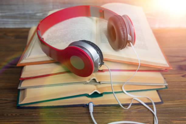 istock Red headphones on a stack of open books. 1159053790