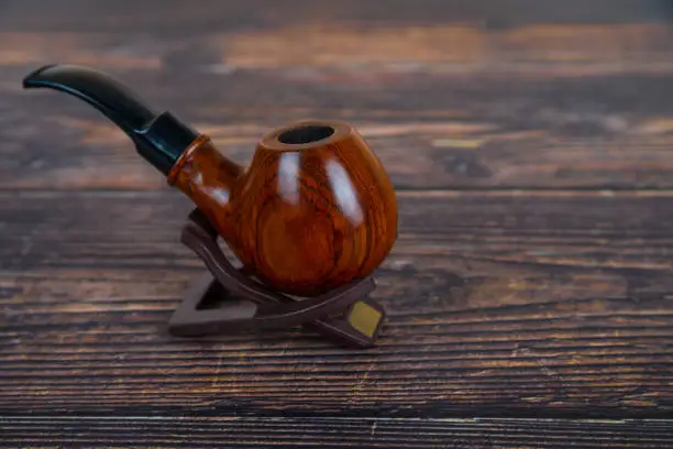 Smoking pipe on the old wooden table. Accessories