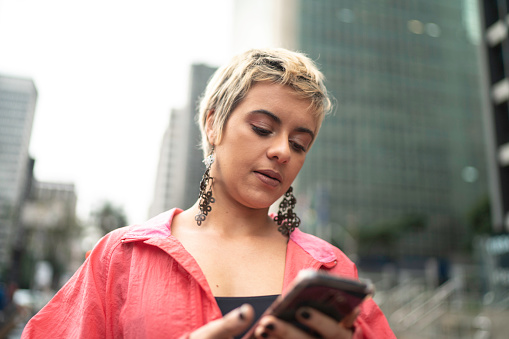 young latin woman using smartphone in the city