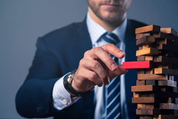 caucasian businessman suit hand hold wooden tower stack block organize and strategy ideas concept - risk management imagens e fotografias de stock