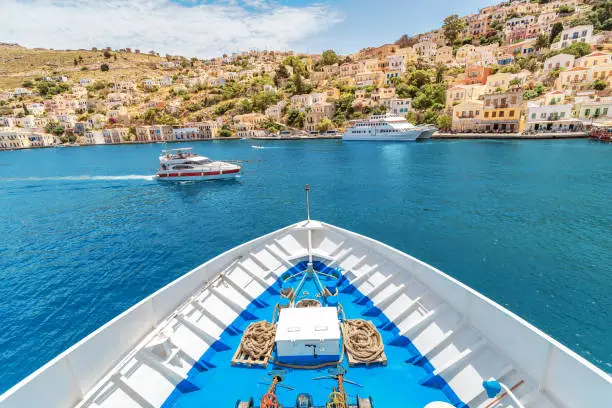 The bow of the cruise ship overlooking the tourist attraction - the city and the island of Symi, Greece