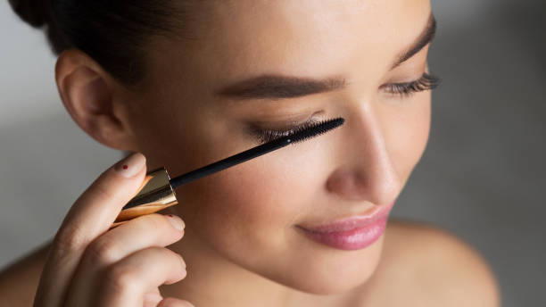 istock Woman Applying Black Mascara on Eyelashes with Makeup Brush 1159063602
