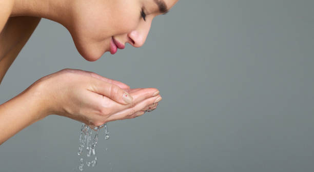 hermosa mujer lavando la cara con el agua, vista lateral - human face water washing women fotografías e imágenes de stock