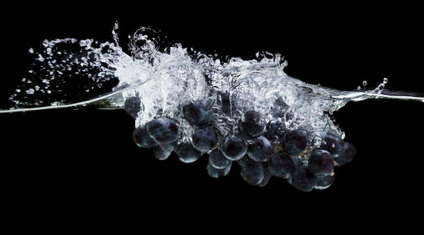 istock Fresh purple grapes in clear water with splash 1159063769