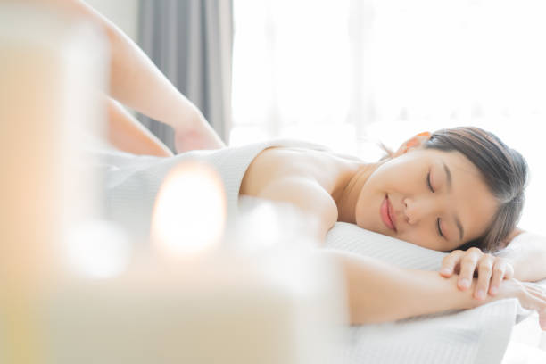 молодая азиатка в спа-салоне получает массаж. - massaging spa treatment health spa women стоковые фото и изображения