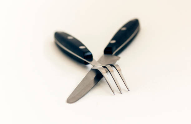 Close up knife and fork crossed, isolated on white background