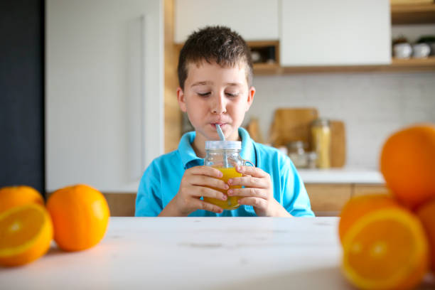 istock Child drinking fresh orange juice 1159069725