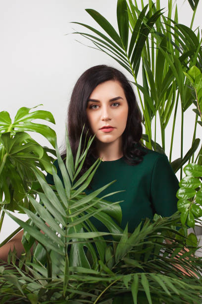 istock Young beautiful woman siting between large home plants. 1159073172