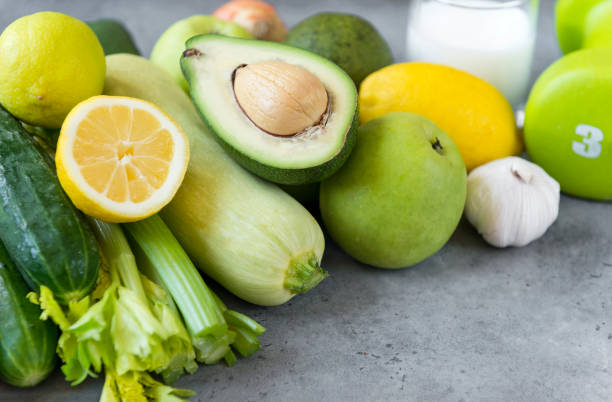 istock green vegetables on grey background, avocado, cucumber, zucchini,  lemon , Apple ,garlic, celery, 1159075326