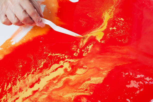 istock How to make acrylic painting. Work in progress. Women's hand smearing paint with a spatula. 1159075633
