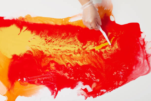 istock How to make acrylic painting. Work in progress. Women's hand smearing paint with a spatula. 1159075666