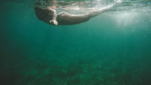 woman swimming in adriatic sea in croatia - leg split imagens e fotografias de stock