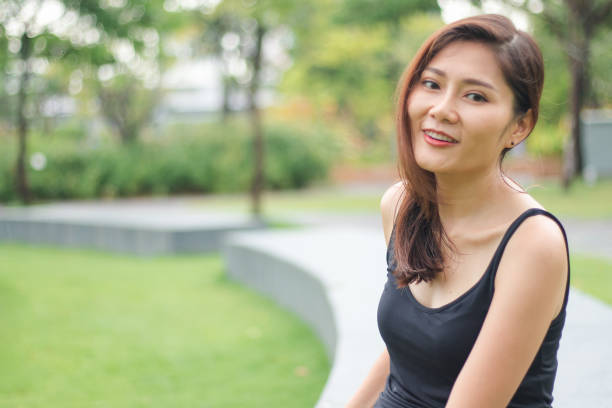 istock woman sat in the park and smiled 1159085306