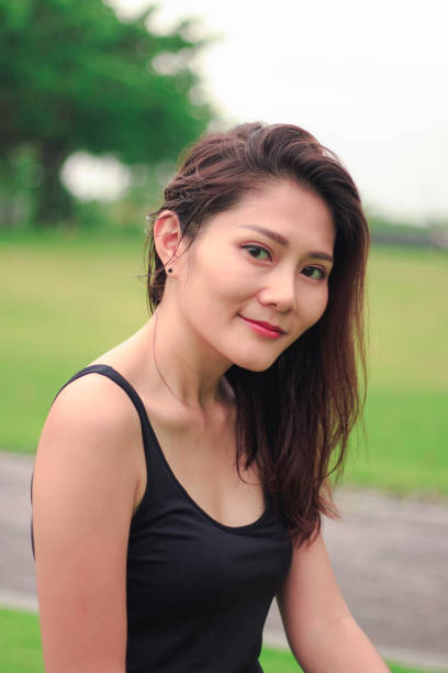 istock woman sat in the park and smiled 1159086327
