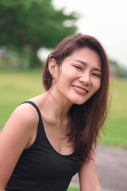 istock woman sat in the park and smiled 1159086456