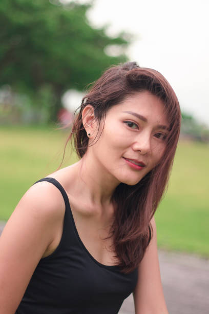 istock woman sat in the park and smiled 1159086460