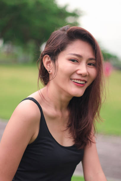 istock woman sat in the park and smiled 1159086470