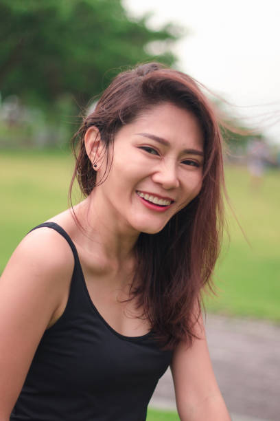 istock woman sat in the park and smiled 1159086476