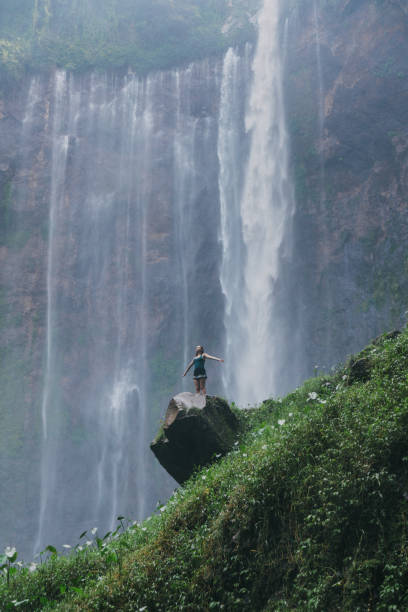 istock Woman standing and looking at Tumpak Sewu waterfall on Java 1159089389