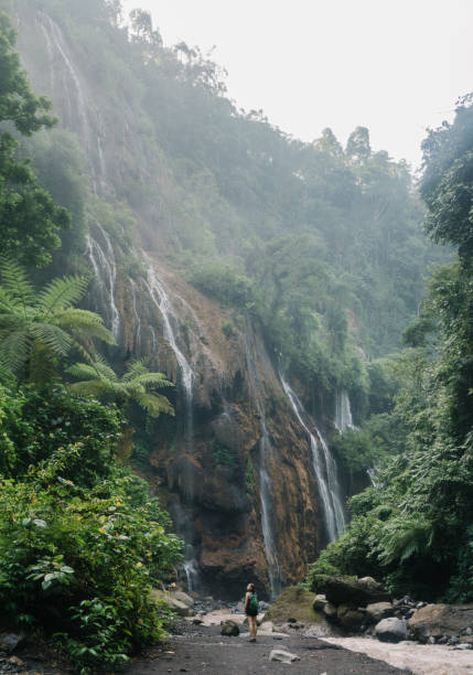 istock Woman walking near Tumpak Sewu waterfall on Java 1159090040