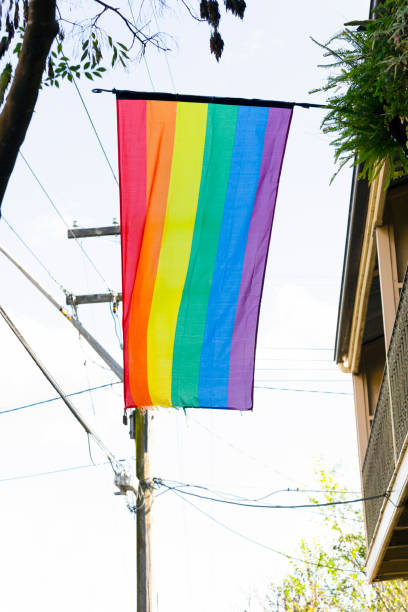 istock Rainbow flag hanging from house, background with copy space 1159090122