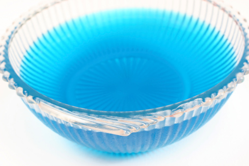 Lovely old bowl with fluted edges and wing-like handles full of blue gelatin.  Shallow DOF with focus on the handle of the bowl.