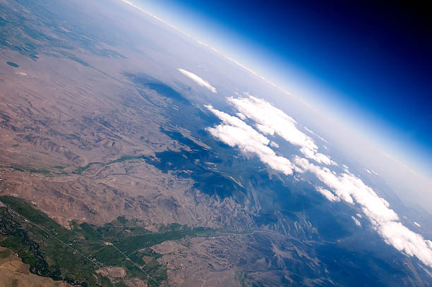 Aerial Cliffs Aerial over mountains edge with clouds hovering over the peaks. stratosphere airplane cloudscape mountain stock pictures, royalty-free photos & images