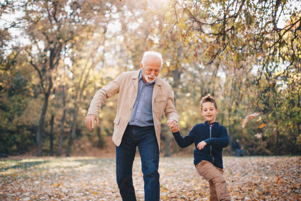 nonno e nipote che camminano all'aperto - grandfather adult affectionate little boys foto e immagini stock