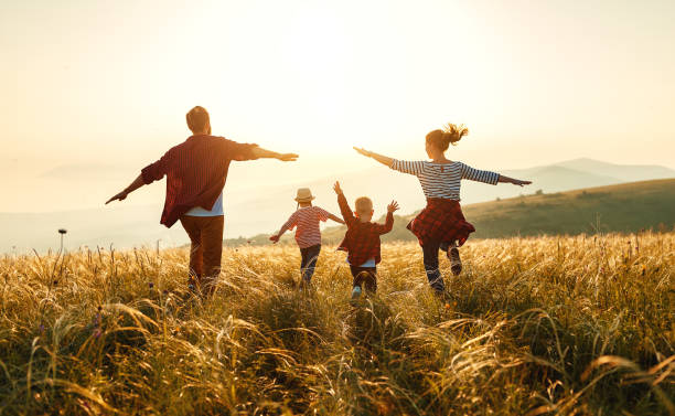 Happy family: mother, father, children son and daughter on sunset Happy family: mother, father, children son and  daughter on nature  on sunset people and lifestyle stock pictures, royalty-free photos & images