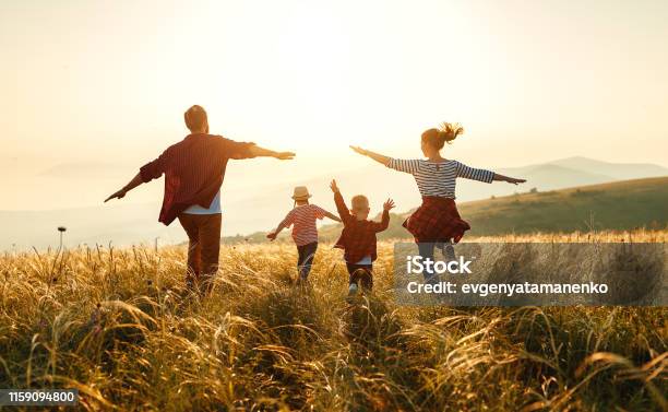 Happy Family Mother Father Children Son And Daughter On Sunset Stock Photo - Download Image Now