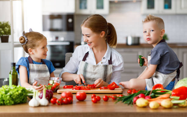 istock mother with children preparing vegetable salad 1159095440
