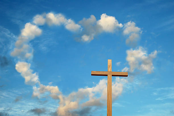 Wooden cross with heart-shaped cloud in background