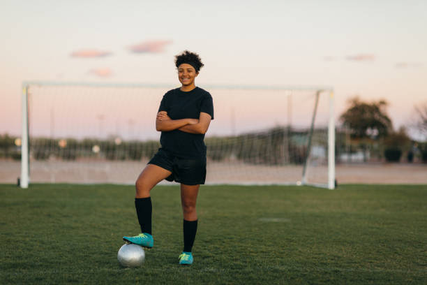 Female High School Soccer Player A female high school soccer player in practice uniform poses for a portrait while on the pitch in Arizona, USA. She is a young woman athlete who loves to compete in the sport of soccer. high school soccer stock pictures, royalty-free photos & images