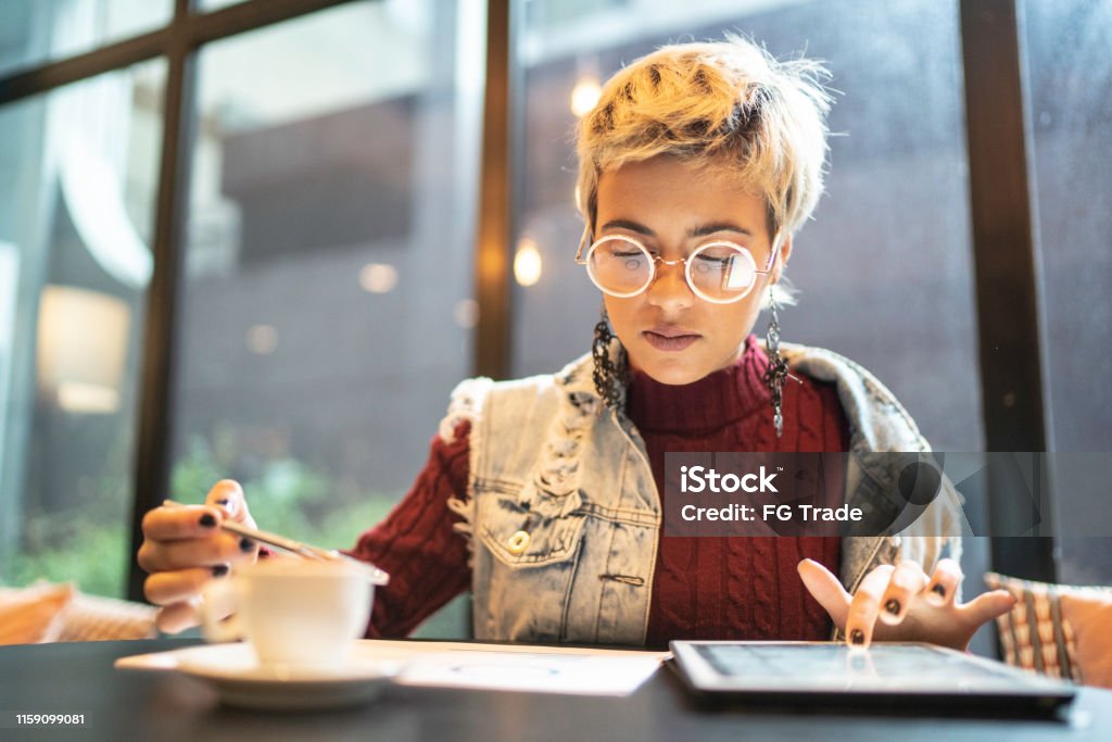 Latin woman checking some graphics from digital investment Generation Z Stock Photo