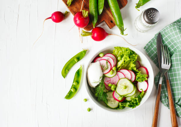 istock Spring vegetable salad with radish, cucumber and green peas, top view, copy space 1159099109