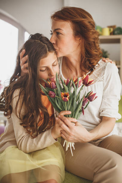 madre affettuosa che bacia sua figlia - mothers day mother kissing child foto e immagini stock