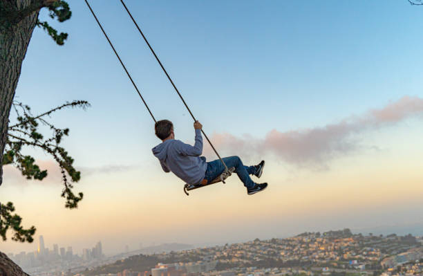 swinging in san francisco bei sonnenuntergang - seilschaukel stock-fotos und bilder