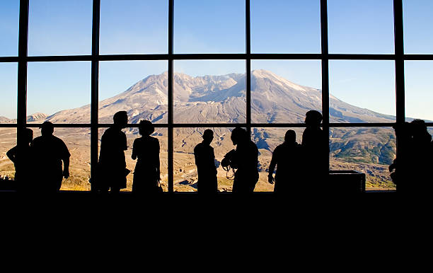 Mt. Saint Helens' Johnston Ridge Observatory Tourists view Mt. Saint Helens through the windows of the Johnston Ridge Observatory. Washington State, USA. Minor waviness in the sky comes from the glass windows. mount st helens stock pictures, royalty-free photos & images