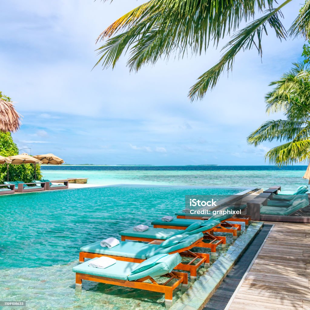 Tanning Beds Beside Swimming Pool in Tropical Resort in Maldives Beach Stock Photo