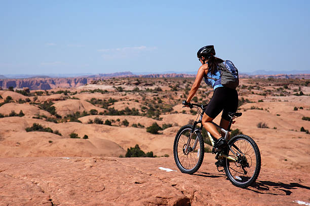 Mountain biking Woman mountain biking on slick rock slickrock trail stock pictures, royalty-free photos & images