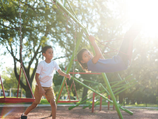 istock Boy pushing his sister on the swings 1159111680