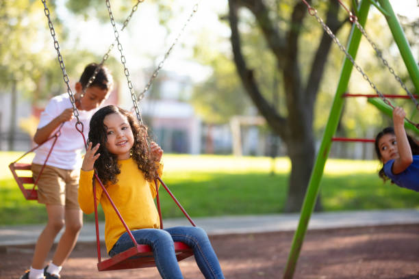 istock Kids playing on the swing set 1159111682